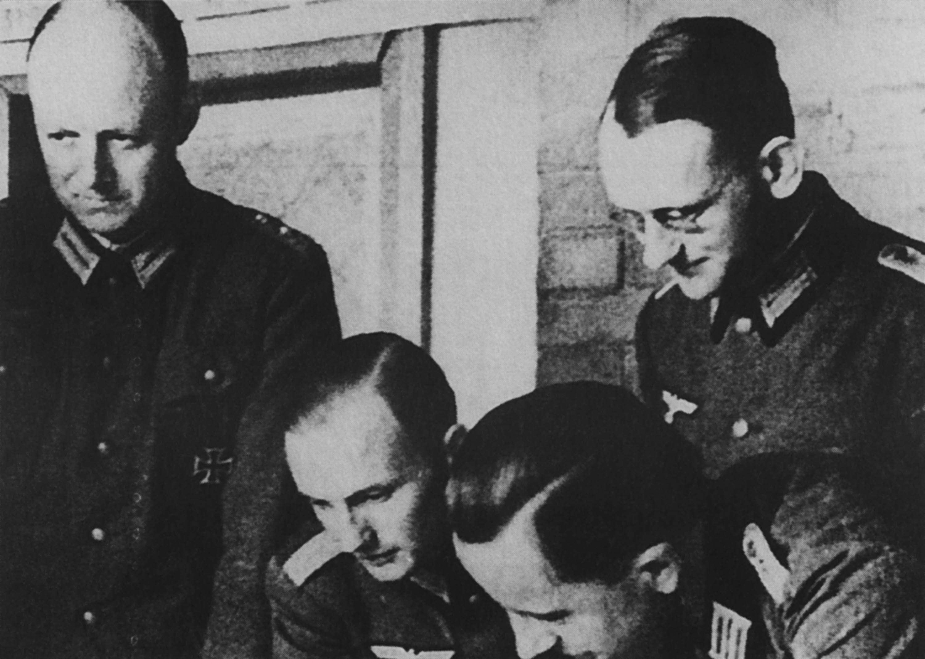 Oberst im Generalstab Henning von Tresckow (stehend, l.) und sein Ordonnanzoffizier Oberleutnant Fabian von Schlabrendorff (stehend, r.) während einer Lagebesprechung beim Stab der Heeresgruppe Mitte, 1942